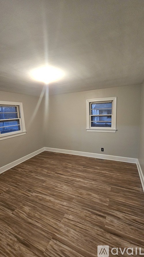 A room with wooden flooring and a window.