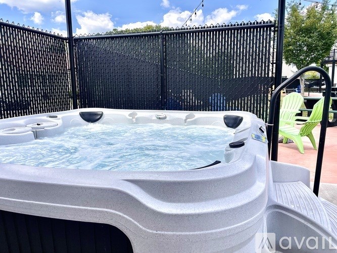 A hot tub with a black fence in the background.
