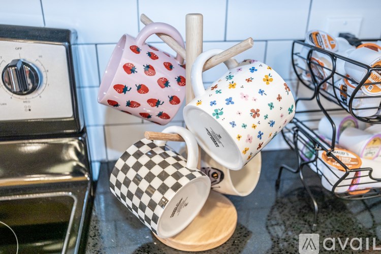 A collection of mugs with different patterns are displayed on a kitchen counter.