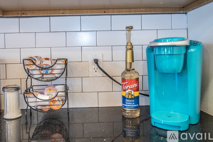 A Torani bottle of French Vanilla sits on a kitchen counter next to a coffee maker.
