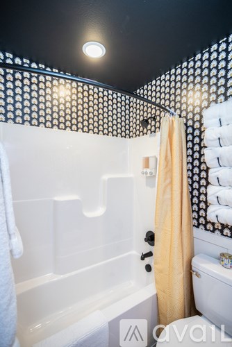 A bathroom with a white tub and a yellow towel.