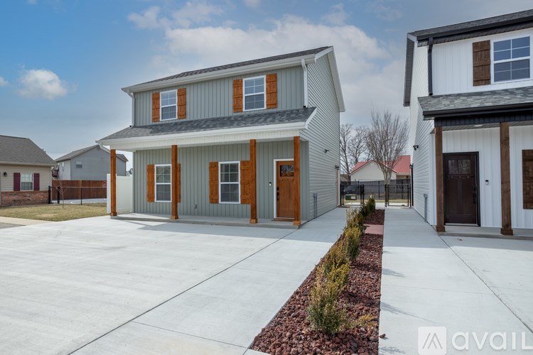 A modern house with a grey and brown exterior and a driveway in front.
