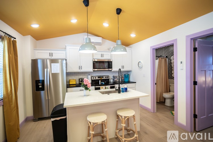 A kitchen with a white counter and a purple door.
