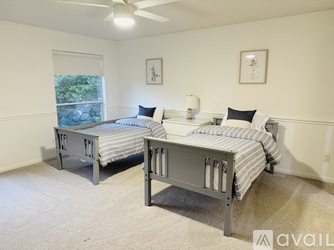 Two twin beds in a room with white walls and carpet.