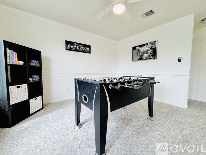 A black foosball table in a room with a sign that says "Game Room".