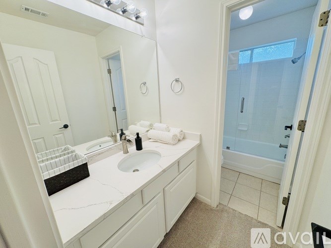 A bathroom with a sink, mirror, and towel.