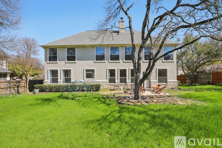A house with a large front yard and a tree in the front.
