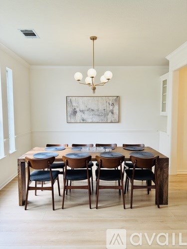 A dining room with a wooden table and chairs.