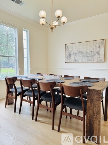 A dining room with a wooden table and chairs.