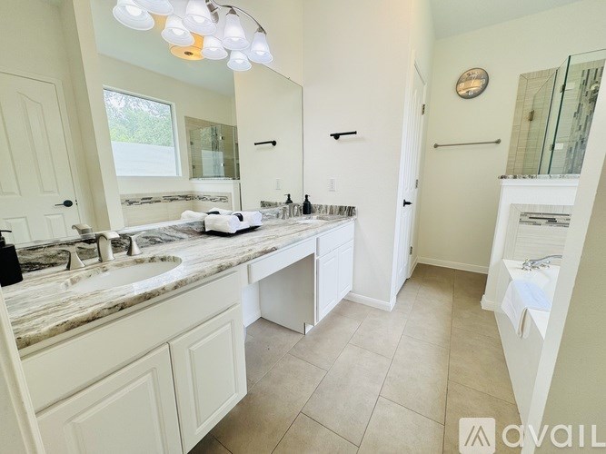 A bathroom with a marble countertop and a large mirror.