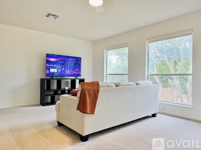 A living room with a white couch and a flat screen TV.