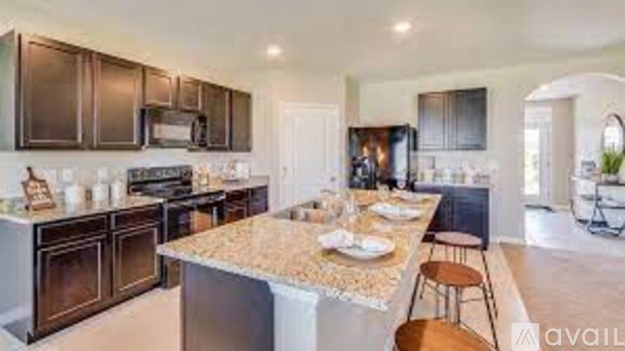 A kitchen with a granite countertop and stainless steel appliances.