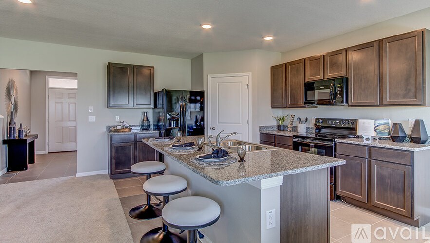 A kitchen with a granite countertop and stainless steel appliances.