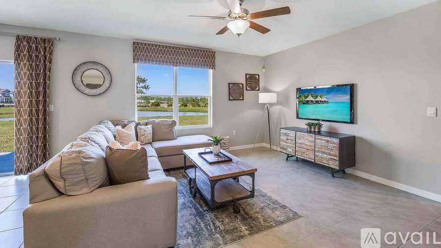 A living room with a couch, a coffee table, and a flat screen TV.