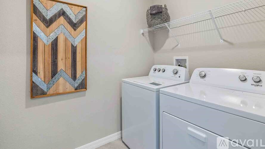 A laundry room with a washer and dryer and a picture on the wall.