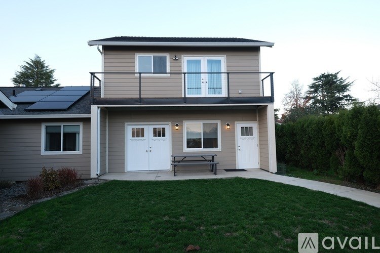 A house with a balcony and solar panels on the roof.