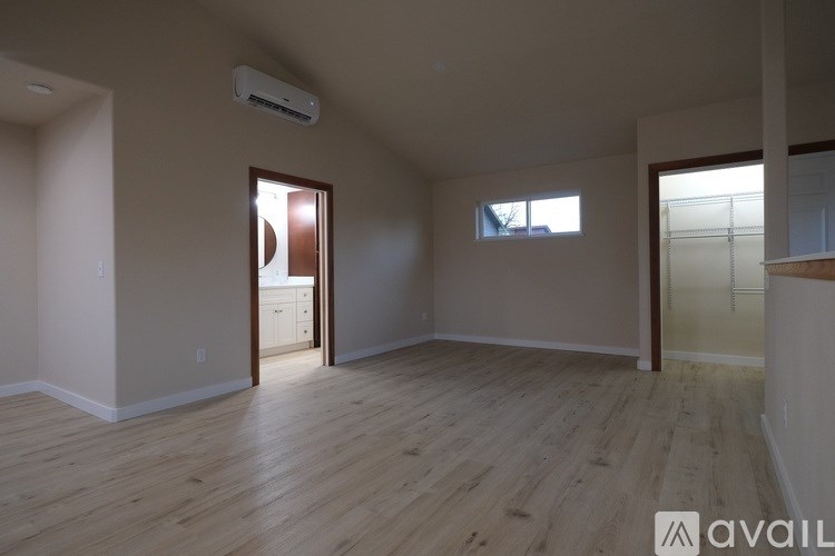A room with wooden flooring and a window.