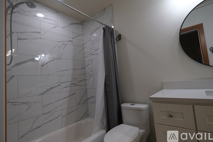 A bathroom with a marble tile shower and a toilet.