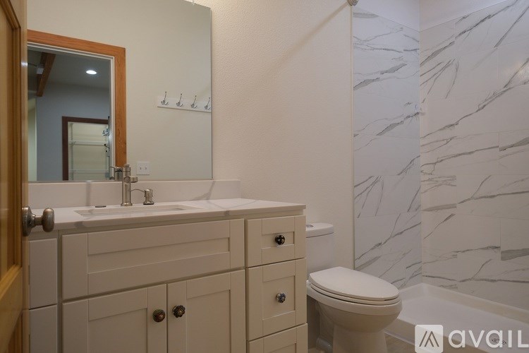 A bathroom with a marble wall and a toilet.