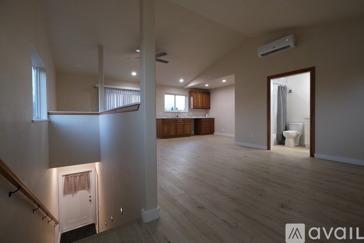 A spacious living room with a staircase leading to the upper floor.