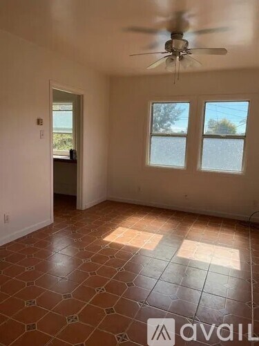 A room with a ceiling fan and tiled flooring.