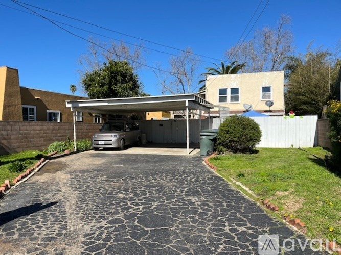 A driveway leads to a garage with a car parked inside.