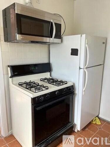 A white stove and oven in a kitchen with a microwave above it and a fridge to the side.