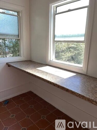 A room with a window seat and tiled floor.