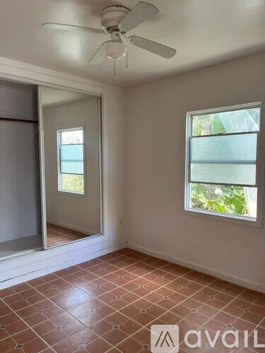 A room with a ceiling fan and a window.