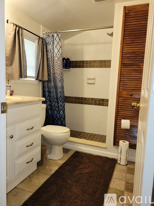 A bathroom with a toilet, sink, and shower.