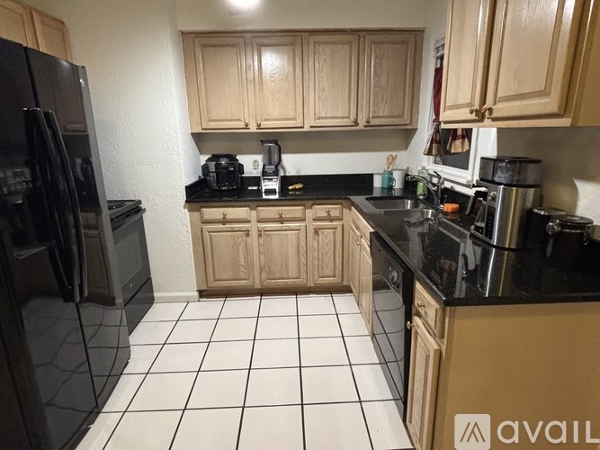 A kitchen with black appliances and wooden cabinets.