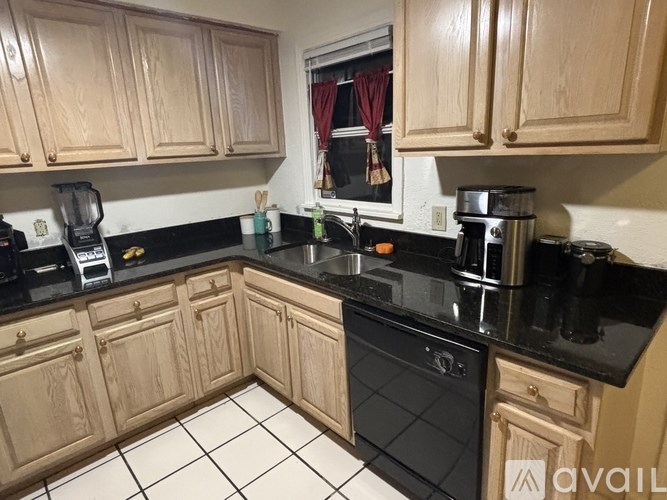 A kitchen with wooden cabinets and black appliances.