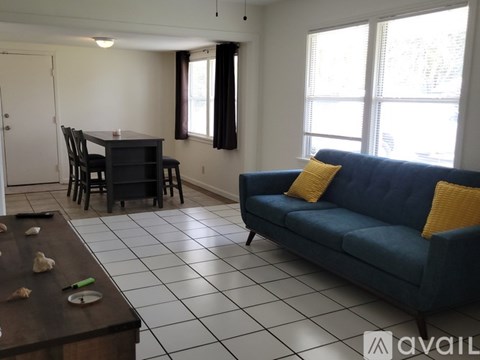 A living room with a blue couch and a dining table.