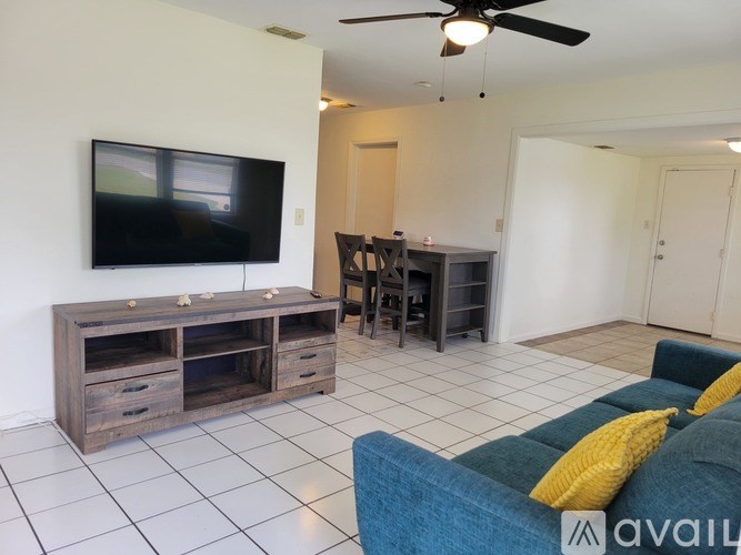 A living room with a television, a blue couch, and a wooden entertainment center.
