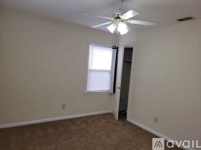 A room with a ceiling fan and a window.
