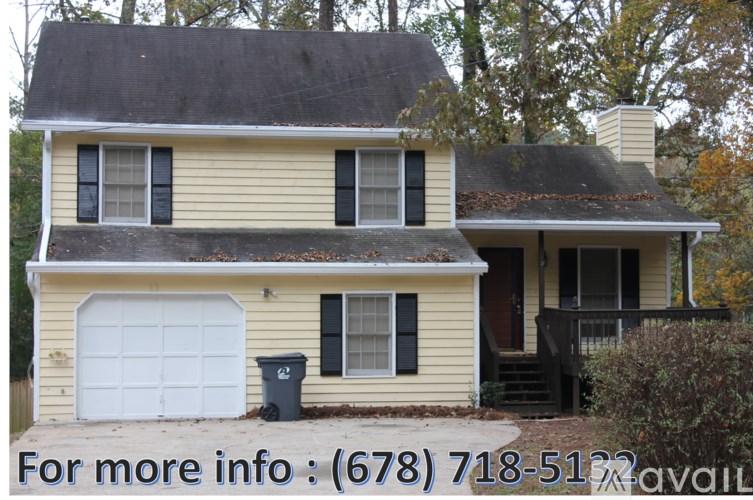 A yellow house with a black roof and a white garage door.