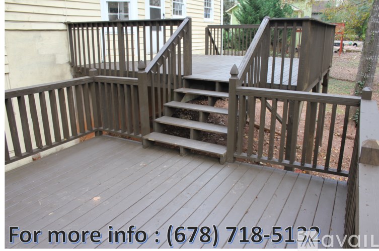 A wooden deck with stairs and railings.