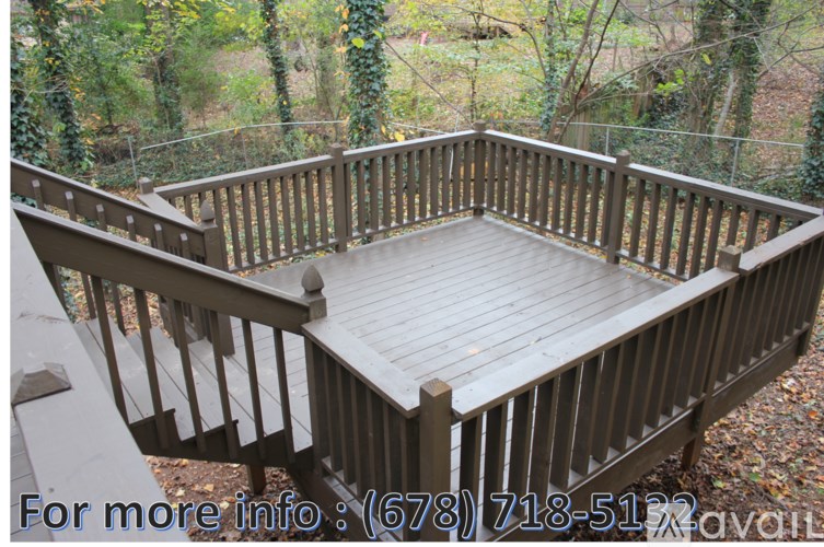 A wooden deck with a railing and a phone number on it.