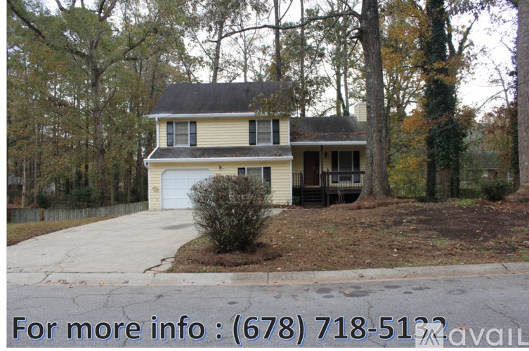 A house with a driveway and a phone number for more information.