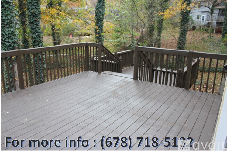 A deck with a railing and steps leading to a house.