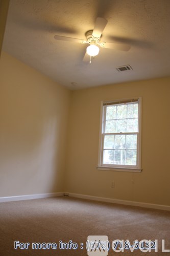 A room with a window and a ceiling fan.