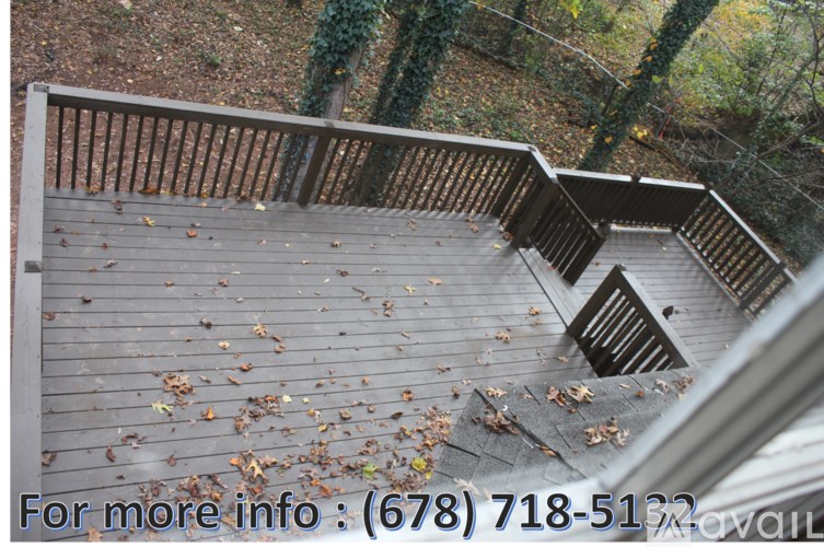 A wooden staircase with a railing and leaves on the steps.