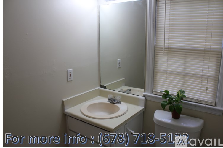 A bathroom with a sink, toilet, and window with blinds.