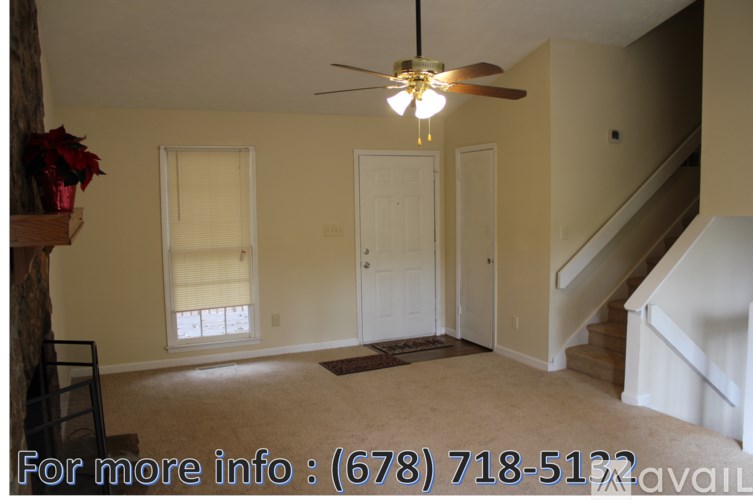A room with a ceiling fan and a staircase.