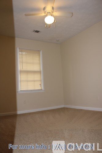 A room with a window and a ceiling fan.