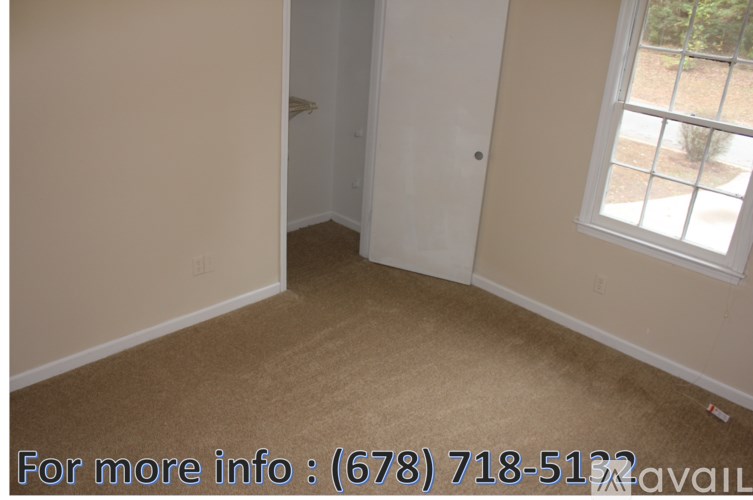 A room with a carpeted floor and a door leading to a balcony.