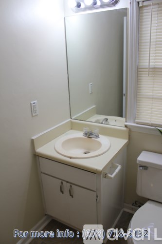 A bathroom with a sink, mirror, and toilet.