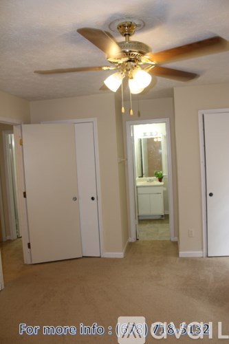 A room with a ceiling fan and a light hanging from it.