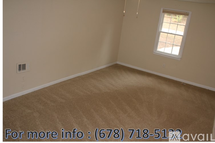 A room with a carpeted floor and a window.