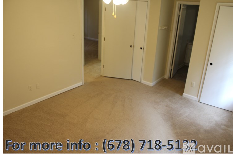 A room with a carpeted floor and a chandelier hanging from the ceiling.